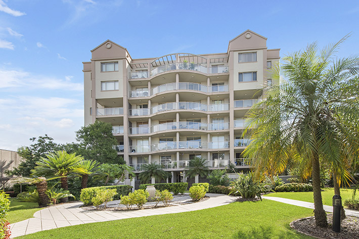 Exterior of multistorey apartment building with gardens at the front